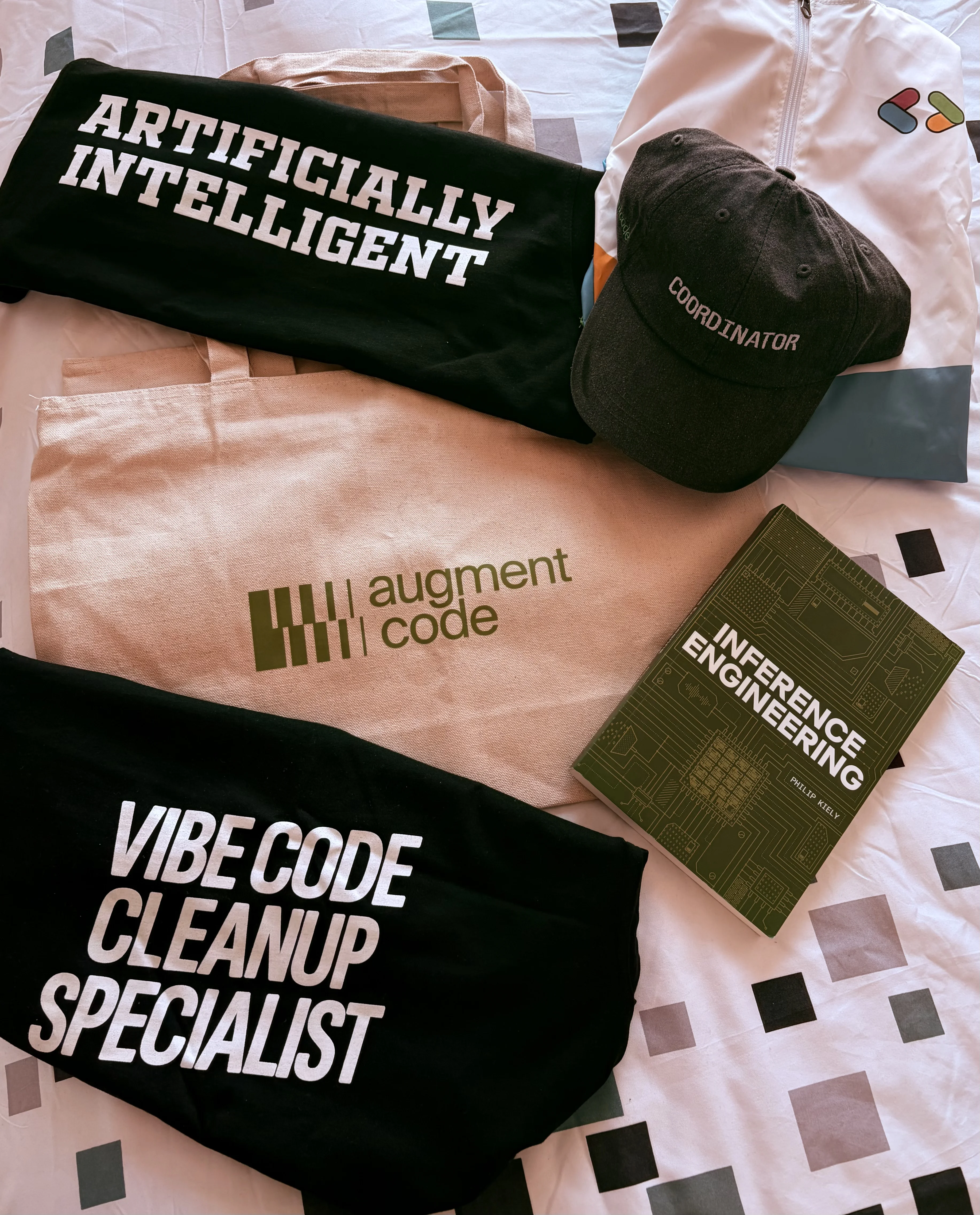 The Inference Engineering book and a few caps and t-shirts from the conference